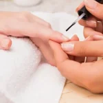 Nail technician giving customer manicure