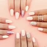 Two women with design manicure holding leather pink bag