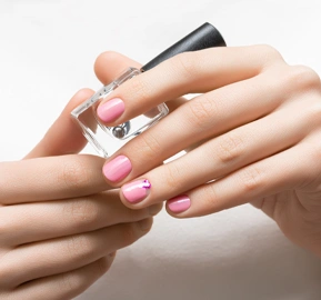 Pink nail design female hand with glitter manicure